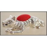 A silver pin cushion in the form of a fox having a