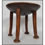 An believed 19th century African hardwood stool having a dished seat being raised raised on