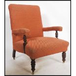 A Victorian library armchair raised on turned legs and brass castors upholstered in damask velour