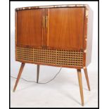 A stunning vintage 20th century Decca valve radiogram, having tambour doors to front opening to