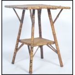 A Victorian mahogany aesthetic movement bamboo occasional table being raised on turned legs at