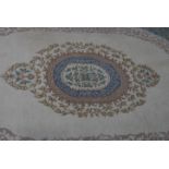 A large Indian Firdosh 20th century floor rug with beige colourway having blue borders with