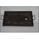 A Jacobean style ebonised oak hand carved butler's tray with brass scrolled handles.
