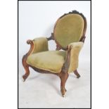A Victorian 19th century walnut spoon back armchair raised on lavishly carved cabriole legs and