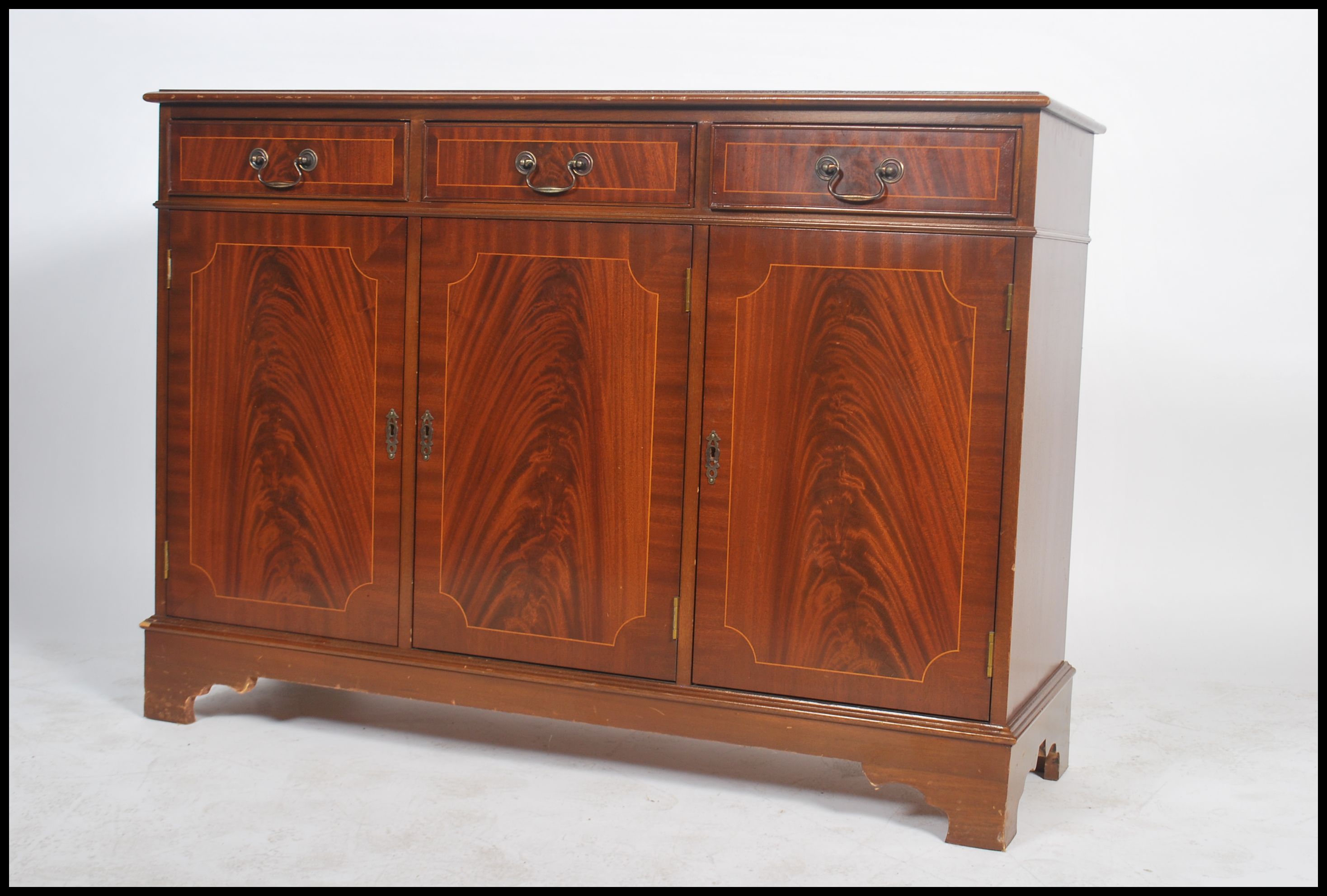 A Georgian style mahogany inlaid sideboard of small proportions being raised on a plinth base with