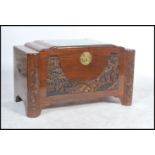 A mid century Chinese - oriental camphor wood blanket box of unusual form, with carved depiction