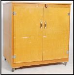 A mid century / 1970's retro beech wood school cupboard having formica top over cupboards with inset
