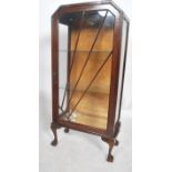An early 20th century china display cabinet raised on ball and claw feet with an Art Deco Rising Sun