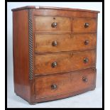 A Victorian mahogany bow front chest of drawers having spiral columns flanking the 2 short over 3