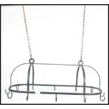 A 20th century cast iron ebonised chain hung pan rack of lozenge shape with hooks to banded sides.