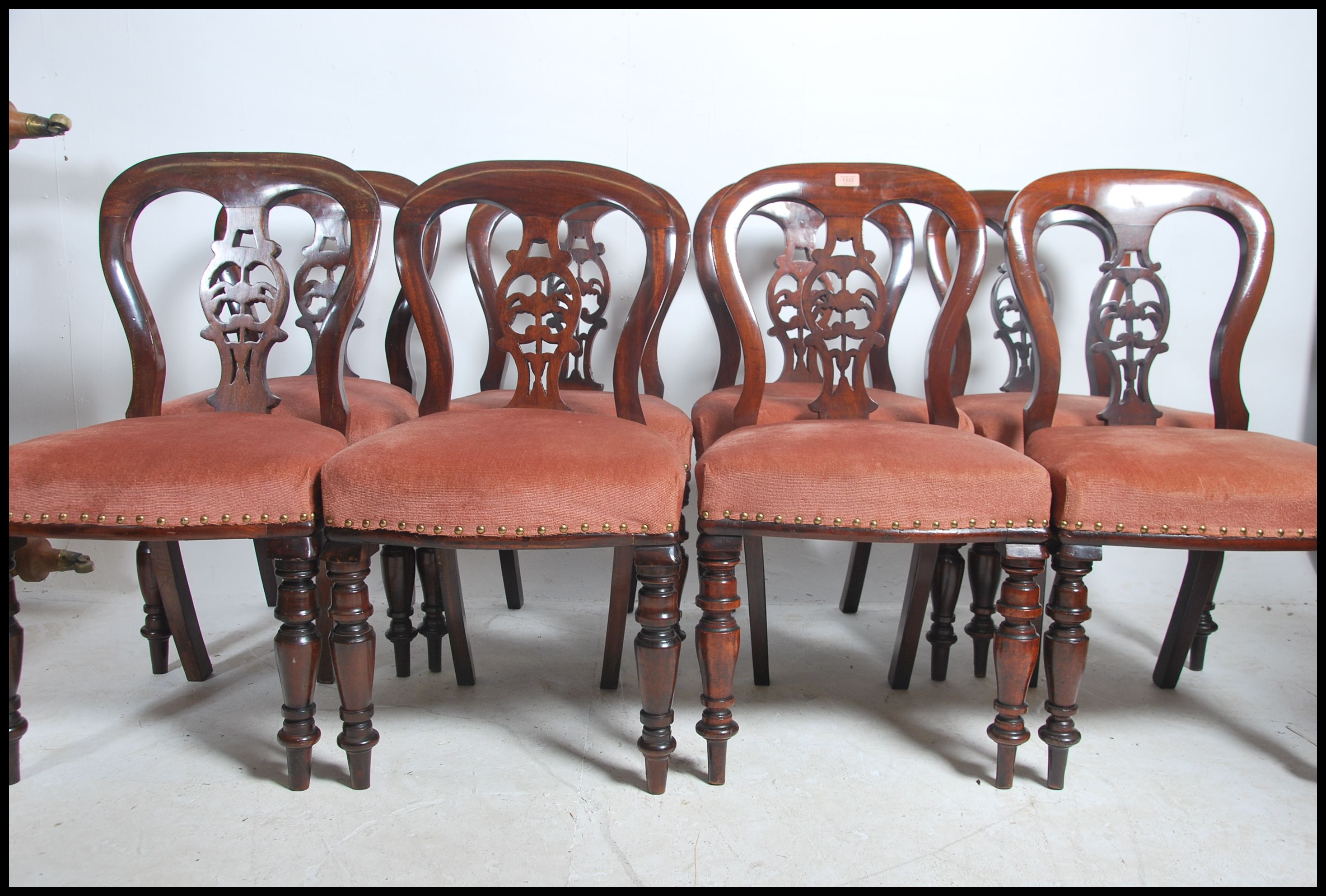 A set of 8 Regency / early Victorian mahogany balloon back dining chairs being raised on turned legs