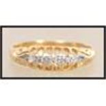 An early 20th century 18ct gold 5 stone diamond ring having a pierced gallery and scrolled