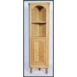 A Victorian / early 20th century pine corner cupboard having a single door cabinet under open