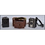 A collection of vintage 20th century cameras to include a Kodak Hawkette No2 folding camera, a box