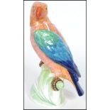 A late 19th century Mintons Majolica parrot hand painted with shades of blue green and orange raised