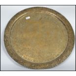 A late 19th / early 20th century large Anglo - Indian brass charger of circular form having chased