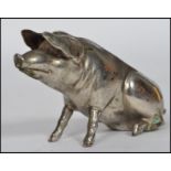 A 20th century novelty silver plated pig pin cushion moulded in a seated position. Lacking cushion