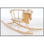 A retro 1960's childs sit on wooden rocking horse having spindle gallery seat with horse head and