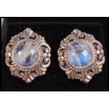 A good pair of ladies silver and moonstone earrings having a rococo style halo to each.  Complete in