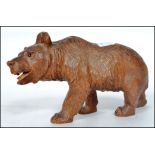 An early 20th century large carved Black Forest bear standing on all four legs, set with glass