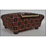 A Victorian /  early 20th century tapestry upholstered footstool in the sarcophagus form being
