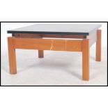 A 1970's Danish influence retro teak and black acrylic top coffee table of square form being