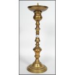 A large early 20th century ecclesiastical Church turned pricker candlestick raised on a large four