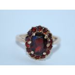 A 9ct gold and garnet cluster ring. Marked 9ct tests 9ct gold. Size L. Weight 3.4g.