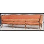 A superb early 20th century french fauteuil sofa being raised on carved cabriole legs with show wood