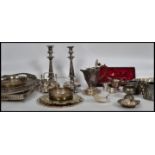 A large collection of silver plated wares to include a pair of large candlesticks, a 4 person egg