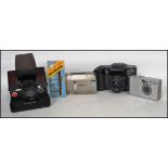 A group of vintage 20th century cameras to include an early Polaroid SX - 70 folding land camera