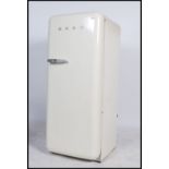 A 20th century SMEG Fridge of upright form having chrome SMEG notation to front and white enamel