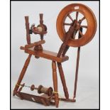 A vintage 20th century pine wood spinning wheel raised on turned legs with wheel and arm to top.