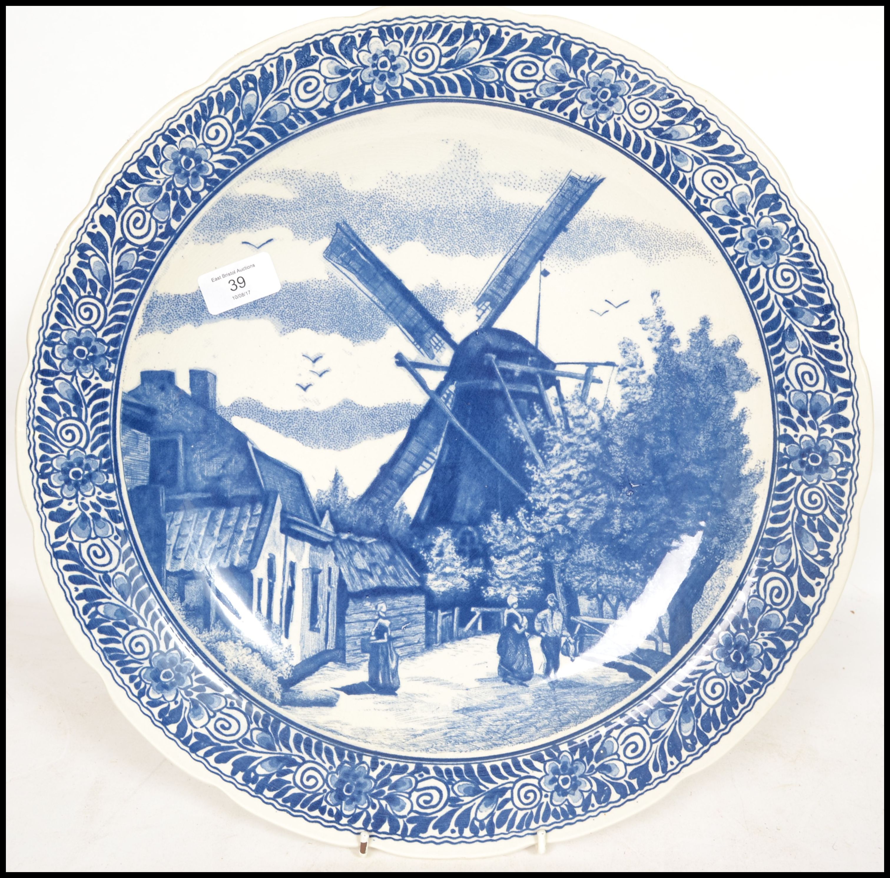 A 20th century Delft ceramic wall hanging charger plate having a central tondo depicting a