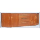 A 1970's retro G-Plan teak wood sideboard of angular form comprising angled end cupboards with a