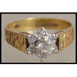 A hallmarked 18ct gold and diamond cluster ring with 7 illusion set diamonds set in a star cluster