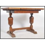 A 1930's oak draw leaf refectory dining table raised on turned legs united by stretcher having