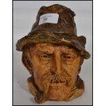 A vintage 20th century studio pottery lidded tobacco jar in the form of a pipe smoking gent with his