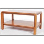 A retro 1970's Danish influence teak wood coffee / occasional table being raised on tapering legs