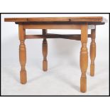 A 1930's oak draw leaf refectory dining table raised on turned legs having fitted frieze with