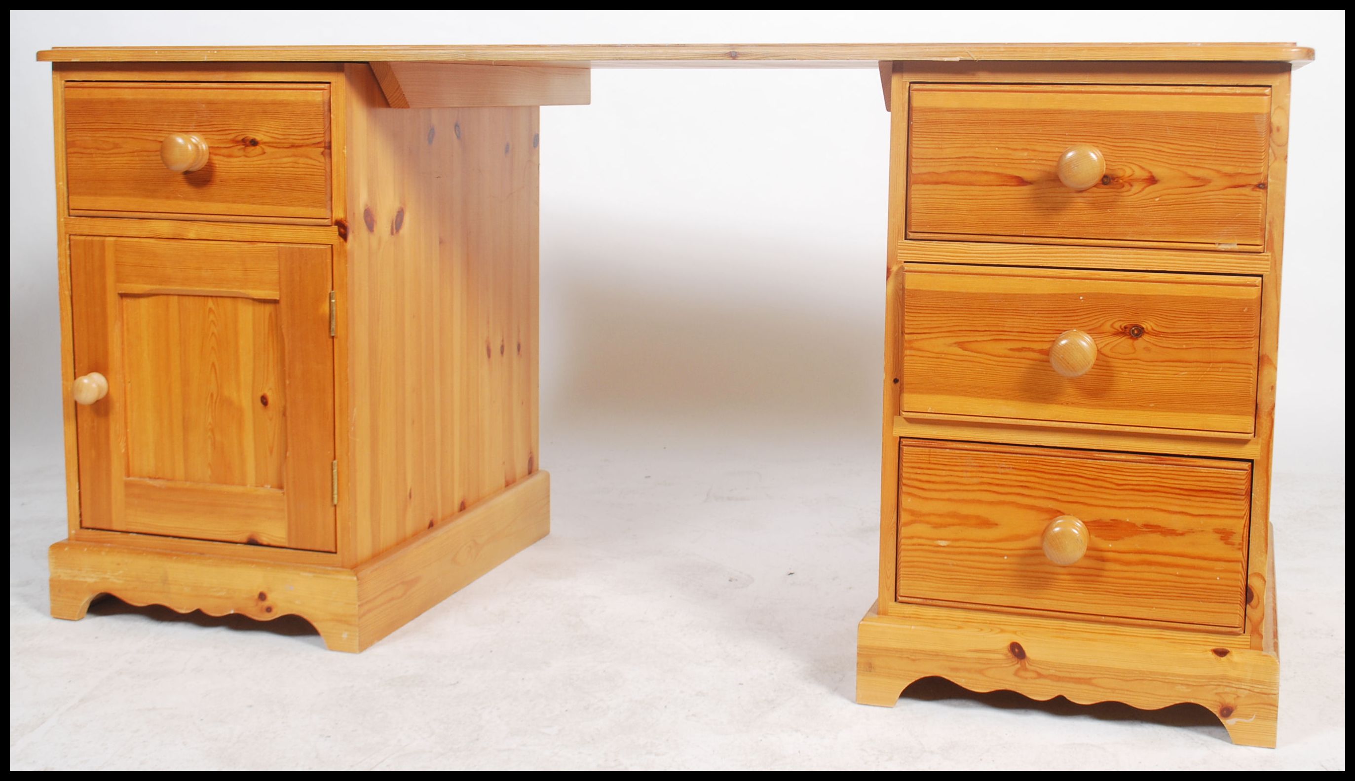 A 20th century contemporary twin pedestal pine knee hole desk having an arrangement of drawers