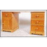 A 20th century contemporary twin pedestal pine knee hole desk having an arrangement of drawers