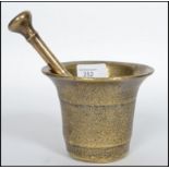 A heavy Oriental 18th century bronze pestle and mortar having a double ended pestle with bell shaped