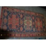 An early 20th century Persian Caucasian rug having gemoetric borders with multiple medallions to the