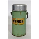 An original vintage metal cased 'Thermos' flask in green with notation to front.