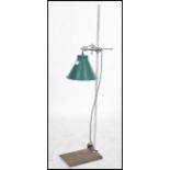 An Industrial mid century laboratory phial stand having applied enamel pendant light with flex.