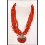 A vintage ladies necklace having multiple rows of carnelian beads with large carnelian medallion