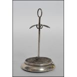 A hallmarked silver hat pin stand of plain design with a hoop top, with a pierced platform to