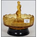 An early 20th century pressed glass centre piece bowl having a raised edge with central figure of