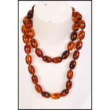 A vintage early 20th century single row, graduated, olive-shaped amberite bead necklace, strung on